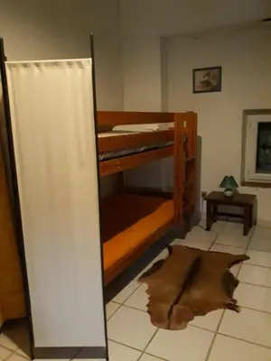 two bunk beds in a room with a rug at Gîte de la Truie qui File in Noailhac