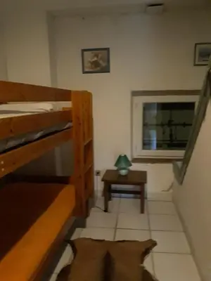 a small room with two bunk beds and a table at Gîte de la Truie qui File in Noailhac