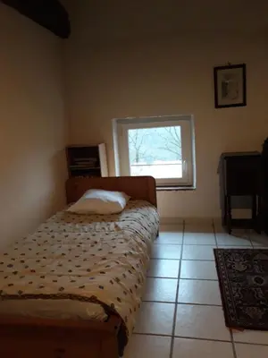 a small bedroom with a bed and a window at Gîte de la Truie qui File in Noailhac