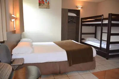 a bedroom with a bed and bunk beds in it at Hôtel Le Floreal in Trèbes