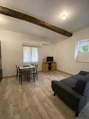 a bedroom with a bed and a table and a dining room at Agréable maison dans petit village calme in Floure