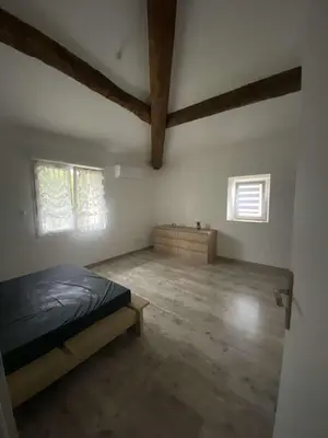 a bedroom with a bed and two windows at Agréable maison dans petit village calme in Floure