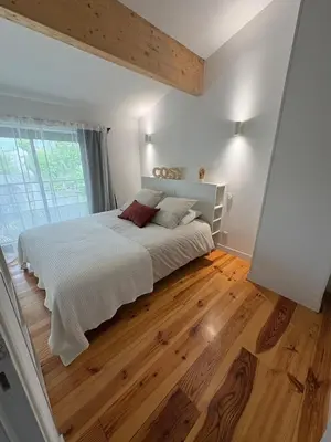 a bedroom with a large bed and a wooden floor at Appartement Loft in Mirepoix