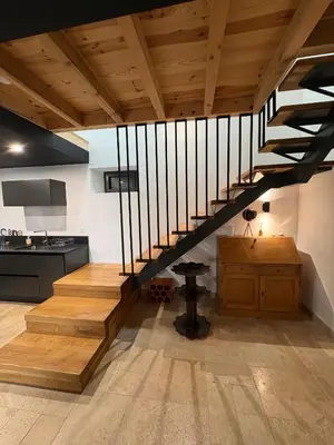 a hallway with white walls and wood floors at Appartement Loft in Mirepoix