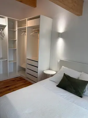a white bedroom with a bed and a window at Appartement Loft in Mirepoix