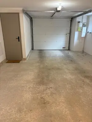 an empty garage with two white garage doors at Appartement Loft in Mirepoix
