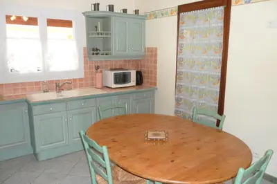 a kitchen with a wooden table and a microwave at Gîte 8 Personnes Piscine Privée Aude Occitanie Sud Corbières in Fabrezan