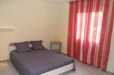 a bedroom with a bed and a red curtain at Gîte 8 Personnes Piscine Privée Aude Occitanie Sud Corbières in Fabrezan