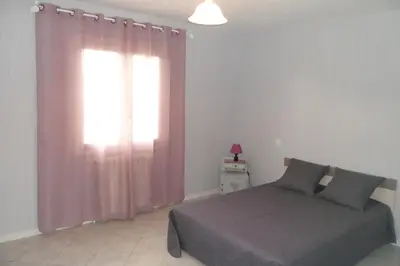 a bedroom with a bed and a window with pink curtains at Gîte 8 Personnes Piscine Privée Aude Occitanie Sud Corbières in Fabrezan