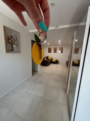 a person holding a pair of keys in a hallway at Chez Cricri, modern accommodation in Bizanet