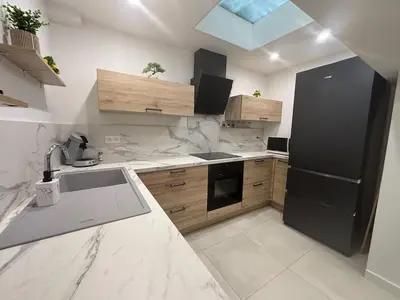 a kitchen with a sink and a black refrigerator at Chez Cricri, modern accommodation in Bizanet