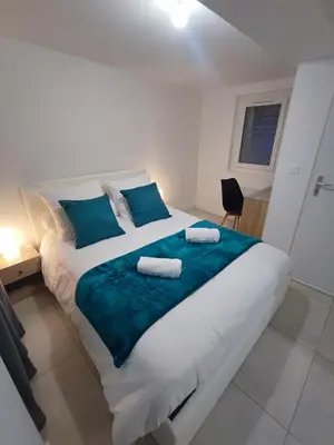 a bedroom with a large bed with two towels on it at Chez Cricri, modern accommodation in Bizanet