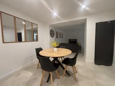 a dining room with a table and black chairs at Chez Cricri, modern accommodation in Bizanet