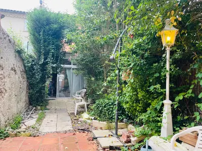 a garden with a street light and a hedge at Appartement avec jardin sous les couverts in Mirepoix