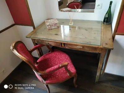 an old desk with a red chair and a mirror at Chez Georges in Carcassonne
