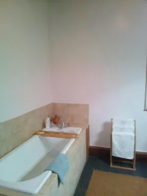 a bathroom with a tub and a sink and a chair at Chez Georges in Carcassonne