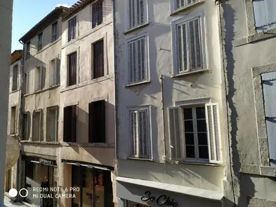 a white building with windows and a store at Chez Georges in Carcassonne