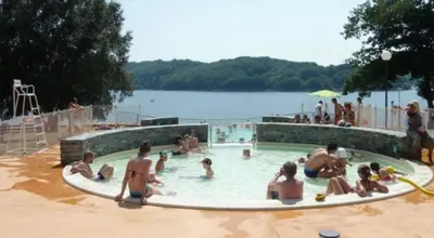 a group of people sitting in a swimming pool at Magnifique Gîte 4 à 10 personnes in Nages