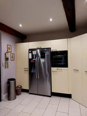 a kitchen with a stainless steel refrigerator and a microwave at Jolie maison de village avec vue in Maury