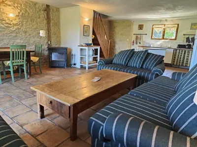 a living room with two couches and a wooden table at Charming farmhouse gite in southwestern France in Montferrand