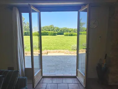 an open sliding glass door with a view of a yard at Charming farmhouse gite in southwestern France in Montferrand