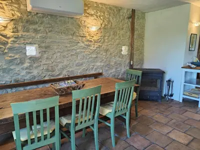 a dining room with a wooden table and chairs at Charming farmhouse gite in southwestern France in Montferrand