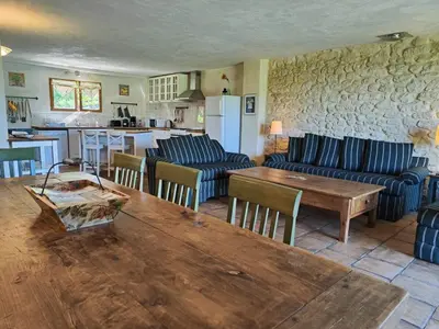a living room with couches and a table and a kitchen at Charming farmhouse gite in southwestern France in Montferrand