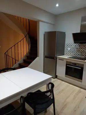 a kitchen with a kitchen table and a staircase at Maison du coutelier in Carcassonne