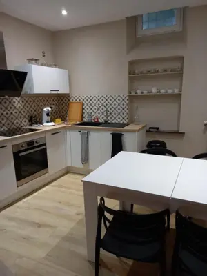 a kitchen with a table and a white counter top at Maison du coutelier in Carcassonne