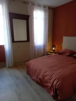 a bedroom with a red bed and a window at Maison du coutelier in Carcassonne