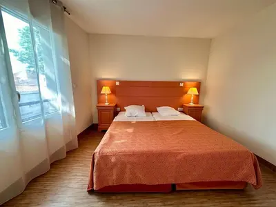 a bedroom with a bed with two lamps on it at T2 à proximité Grand Buffets in Narbonne