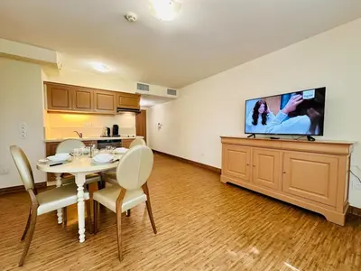 a dining room with a table and a tv on a wall at T2 à proximité Grand Buffets in Narbonne