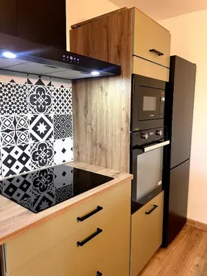 a kitchen with a stove top oven next to a microwave at Plage à 15 min - Proche de la Gare - 6 personnes - 3 Chambres - Idéal Famille in Narbonne