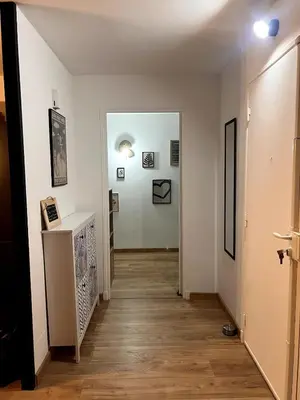 a hallway with white walls and a wooden floor at Plage à 15 min - Proche de la Gare - 6 personnes - 3 Chambres - Idéal Famille in Narbonne