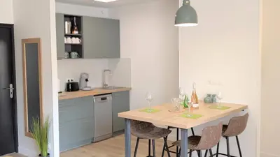 a kitchen with a table with wine glasses on it at 151 - Terrasse & Jacuzzi, Rue Trivalle, Pied de la cité de Carcassonne - Climatisation, Netflix, Fibre in Carcassonne