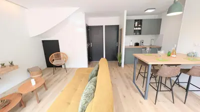 a living room with a couch and a table at 151 - Terrasse & Jacuzzi, Rue Trivalle, Pied de la cité de Carcassonne - Climatisation, Netflix, Fibre in Carcassonne