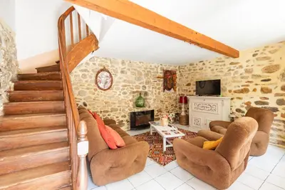 a living room with a staircase and a fireplace at La Campagnarde - Avec jardin clos in Campagne-sur-Aude