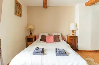 a bedroom with a white bed with towels on it at La Campagnarde - Avec jardin clos in Campagne-sur-Aude