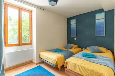 a bedroom with two beds and a window at La Campagnarde - Avec jardin clos in Campagne-sur-Aude