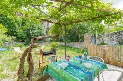 a table and chairs in a garden with a tree at La Campagnarde - Avec jardin clos in Campagne-sur-Aude