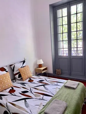 a bedroom with a bed and a window at Le PALACE, Auberge in Carcassonne