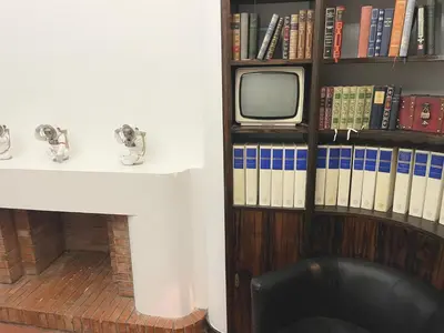 a room with a tv and a shelf with books at Le PALACE, Auberge in Carcassonne