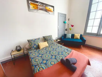 a bedroom with a bed and a couch in it at Le PALACE, Auberge in Carcassonne