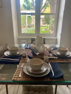 a table with plates and wine glasses on it at Les gites du tilleul in Villefranche-de-Lauragais