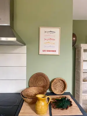 a table with baskets and a picture on the wall at Les gites du tilleul in Villefranche-de-Lauragais