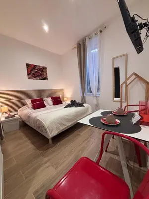 a bedroom with a bed and a table in it at La Rubis in Narbonne
