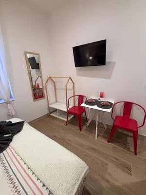 a living room with a table and chairs and a tv at La Rubis in Narbonne