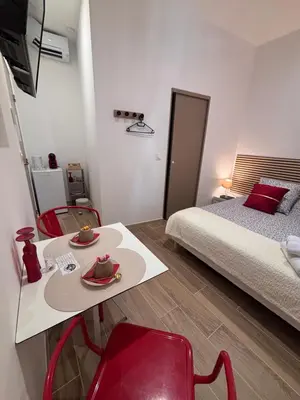 a small room with a bed and a table and chairs at La Rubis in Narbonne