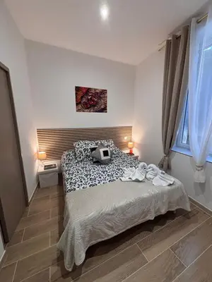 a bedroom with a large bed and a window at La Rubis in Narbonne