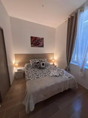 a bedroom with a large bed and a window at La Rubis in Narbonne